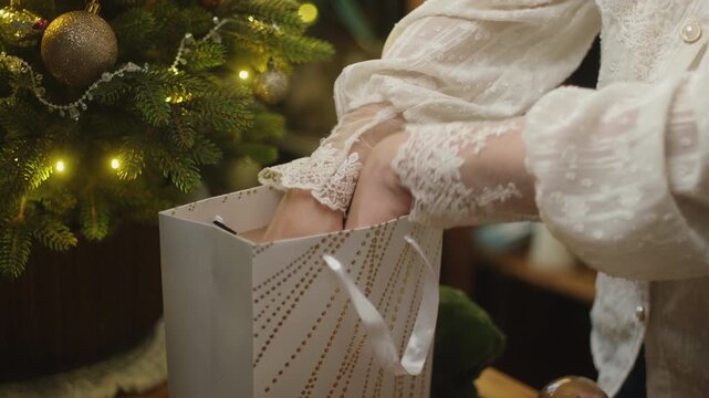Woman collecting Christmas presents in a gift bag. Concept of giving gifts for Christmas or donating gifts for children