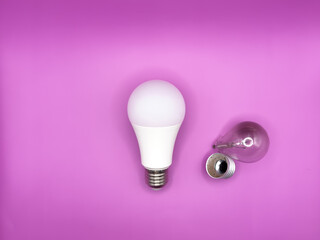 Modern LED lamp, saving electricity. Tungsten light bulb lamp. Non-working light bulb, broken light bulb. Concept of light and dark, idea, electricity copy space, flay lay, top view purple background.