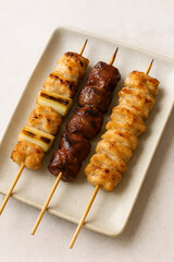 A typical list of items one might order at a yakitori restaurant.
From left there are a chicken and onion, liver and skin skewer.
