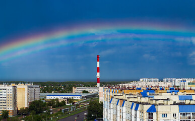 Fantastic beautiful rainbow over city buildings after rain