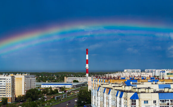Fantastic beautiful rainbow over city buildings after rain