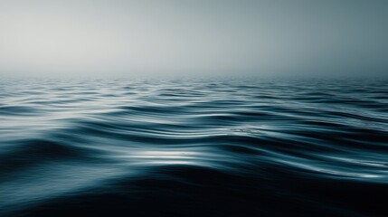 Obraz premium Serene and Tranquil Ocean Surface Captured in Soft Hues of Blue and Gray with Gentle Waves and Misty Horizon Evoking Calmness and Peacefulness