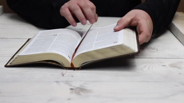 Opening a leather bible to pray and read from scripture, leaning into faith through the words of God