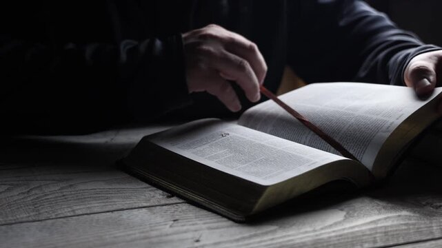 young man opening a book to marked page to read a chapter out of the book