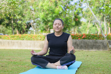 Woman Meditating Peacefully in a Park on a Yoga Mat