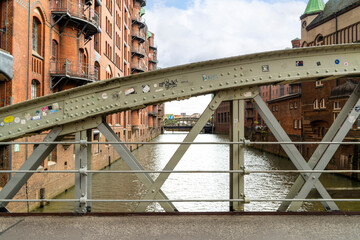 Arched steel and wooden bridge against the iconic brick architecture.