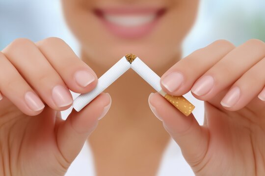 Woman breaking a cigarette in half with her hands, symbolizing the decision to quit smoking, showcasing determination and a healthier lifestyle choice for personal well-being - Powered by Adobe