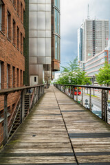 Elevated wooden pedestrian walkway surrounded by modern and historic architecture in Hamburg.