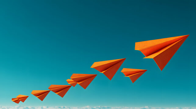 Orange paper airplanes flying upward in perfect formation across blue sky with horizon and soft clouds evoking optimism and movement