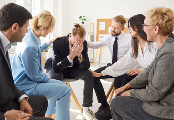 Friendly business people group sitting in a circle supporting young man with his problem during...