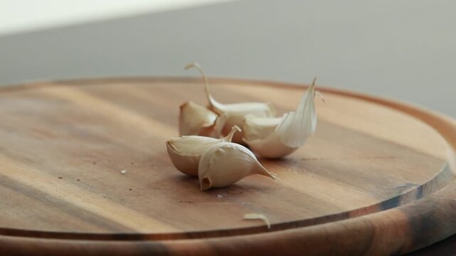fresh garlic cloves on wooden cutting board