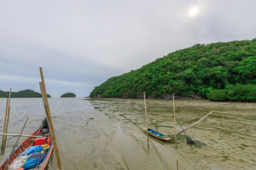 Boat is sitting in the water next to a dock