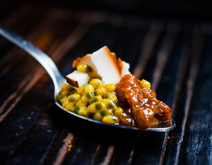 Macro Spoon with Passionfruit Seeds, Fresh Coconut Pieces, and Caramelized Paste on Dark Wooden Background