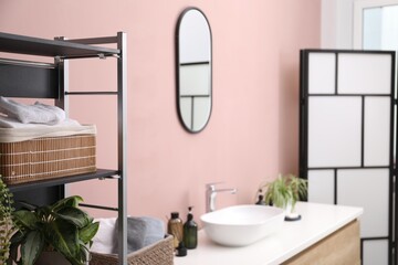 Stylish bathroom interior with mirror, vessel sink and houseplants