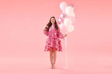 Beautiful woman with balloons on pink background