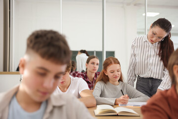 Teacher and students during lesson in classroom, selective focus