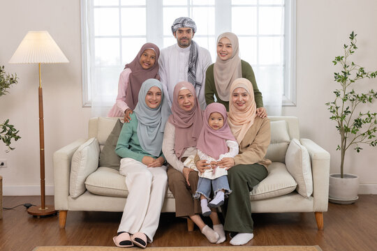 Happy Muslim family portrait at home, smiling together across three generations. Concept of Islamic tradition, family love, cultural diversity, togetherness and multigenerational bonding. - Powered by Adobe