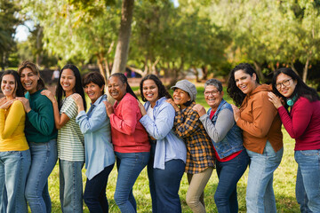 Multiracial women standing in a line and smiling on camera - Multi generational group of people having fun together at park - Feminism, community and international women's day