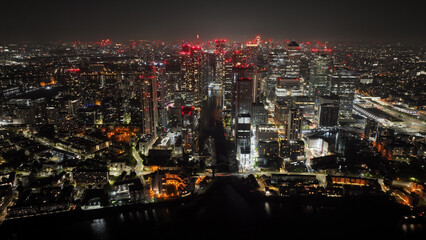 Aerial drone night shot of iconic illuminated modern skyscraper complex of Canary Wharf , London, United Kingdom