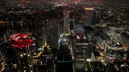 Aerial drone night shot of iconic illuminated modern skyscraper complex of Canary Wharf , London,...