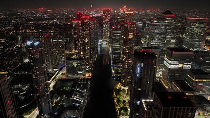 Aerial drone night shot of iconic illuminated modern skyscraper complex of Canary Wharf , London,...
