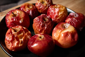 Baked apples arranged on a black plate, cooked to perfection for a cozy dessert experience