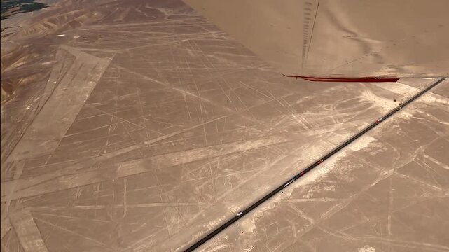 Mysterious Nazca Lines, a UNESCO World Heritage site, showing the intersection of ancient art and modern infrastructure with a highway nearby, filmed from above in a small plane