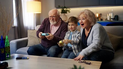 Happy grandparents and little grandson playing video games, fun time together - Powered by Adobe