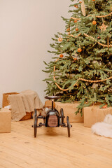 Christmas tree with wooden toys and wrapped gifts in a cozy minimal holiday interior