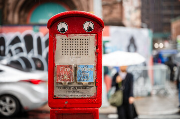 Vintage emergency call box in rainy urban street