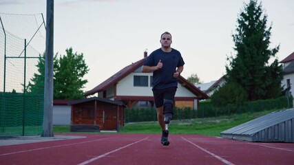 Sports activities on a track, an amputee male athlete using an orthopedic mobility aid, a running blade prosthesis during training, front view. - Powered by Adobe