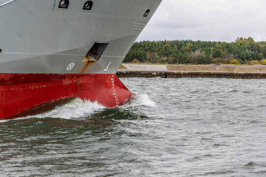 Close-up of Ship's Hull with Draft Marks and Water Spray