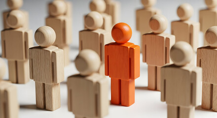 Orange wooden figure stands out among a crowd of beige figures symbolizing leadership individuality and uniqueness in a team or organization highlighting diversity and standing out from the rest