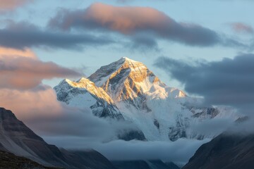 Majestic snow capped mountain peak illuminated by golden sunrise light
