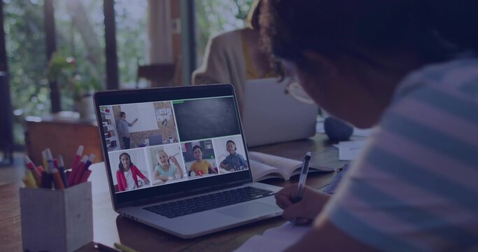 Writing girl wearing striped shirt joining online class at home using laptop pencil cup, copy space