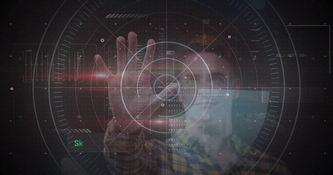 Manipulating adult male extending hand toward holo reticle at dark tech demo, yellow plaid shirt