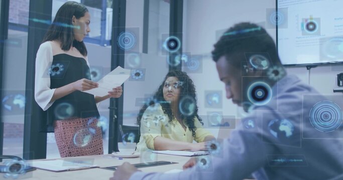 Presenting woman in black top with documents at meeting table with monitor HUD overlays, copy space