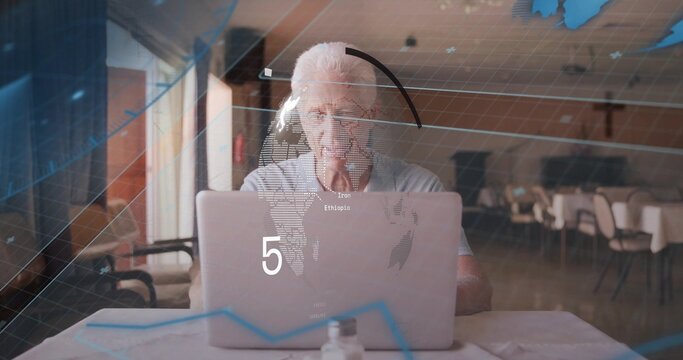 Working senior man focusing on laptop screen at communal dining room, with digital map overlay - Powered by Adobe