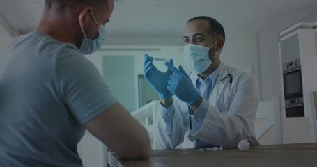 Examining physician in white lab coat holding up small vial in home kitchen, wearing blue gloves