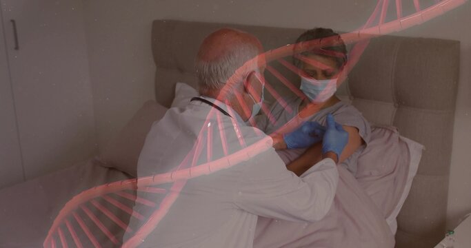 Injecting clinician in coat holding syringe to masked patient in bed with padded headboard, DNA