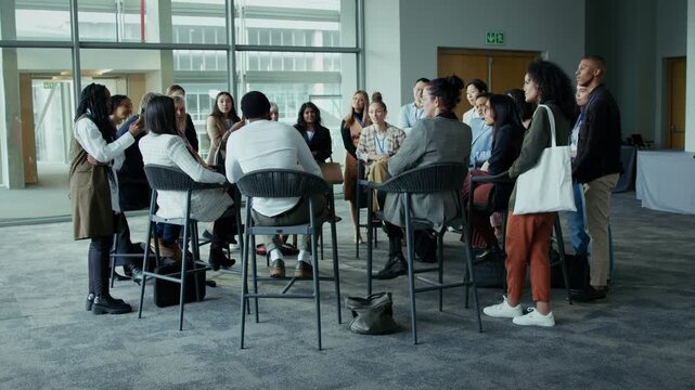 Group of professionals engaging in a collaborative discussion at a large event. Colleagues exchange ideas and network during a conference or workshop session.