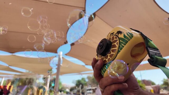 Salesman holding A kids san diego zoo bubble cameras for sale in This Al Ain Zoo 