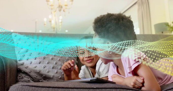 Girl tapping tablet while boy pointing on couch, animated dot wave revealing learning content