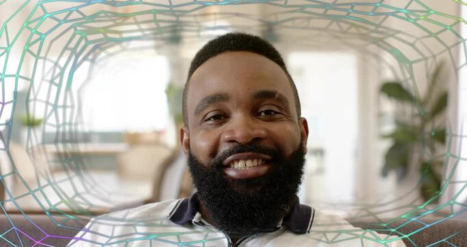 Man sitting couch recording starting, mesh appearing around frame smiling laughing during interview