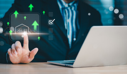 Businessman touching glowing digital house icon with rising arrows and checklist symbolizes real estate growth, property selection, investment decisions, and smart housing analytics in modern market.