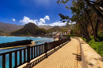 View of the rocky coast and the blue Atlantic ocean with waves on a beautiful sunny day in Madeira (Porto da Cruz), nature background or travel wallpaper
