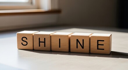 Inspirational message shine spelled out in wooden blocks against window