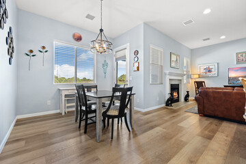A cozy living room featuring a table, chairs, and a fireplace