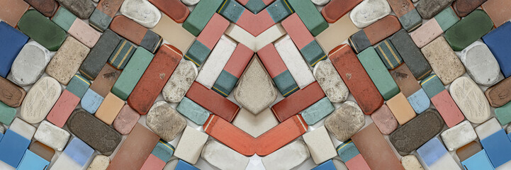 A collection of various used and worn-out erasers, flat lay photograph of a scattered collection of vintage, heavily used, and well-worn rectangular erasers