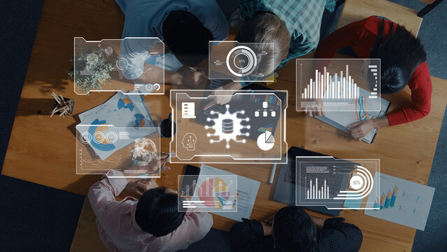 A diverse team engages in a collaborative project, utilizing advanced digital interfaces and data visualizations to enhance their innovative strategies in a modern workspace. Trope